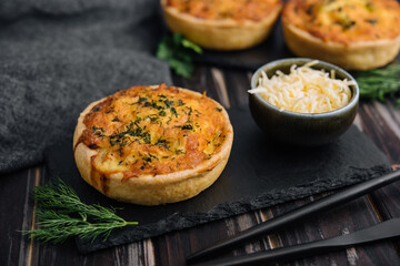 Cheddar cheese and spring onion omelette tarts served on wooden board