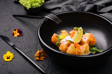 fried crispy shrimp on black plate`