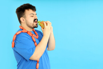 Concept of weight problems, young fat man on blue background