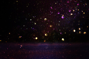 background of abstract glitter lights. gold, purple and black. de focused