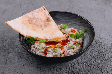 Eggplant caviar with lavash on black bowl