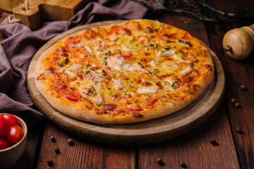 Delicious pizza with seafood on wooden stand