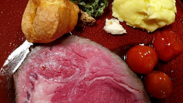 Slice of medium rare roasted beef steak with gravy pudding spinach mashed potato