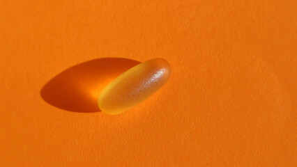 Fototapeta Dietary supplementation. omega-3 fish fat oil capsules. Orange background. obraz