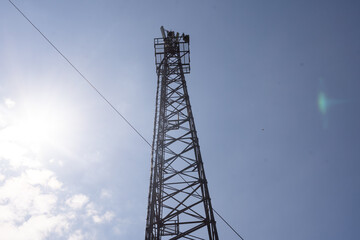 Telecommunication tower of 4G and 5G cellular. Macro Base Station. 5G radio network telecommunication equipment with radio modules and smart antennas mounted on a metal on cloulds sky background..