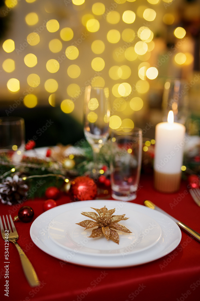 Wall mural Table served for festive dinner at home. Living room decorated with lights