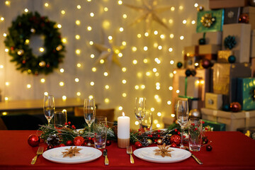 Beautiful decorated table with plates and champagne glasses for family christmas dinner