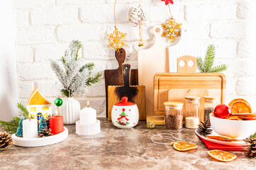 Beautiful view of the decorated kitchen countertop for the New Year and Christmas. burning candles, branch in a vase, slices of dried orange.