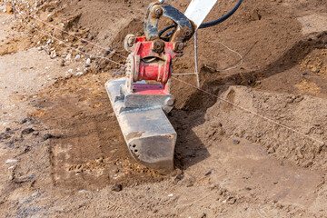 levelling fresh potting soil with the scoop of a digger