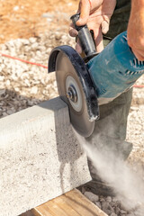 worker with a cutting flex cuts a concrete curb