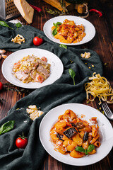 different pasta dishes on wooden with fabric background