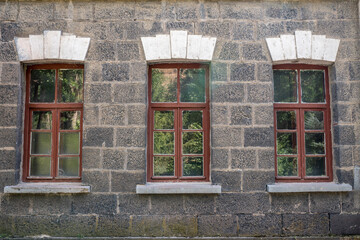 Fototapeta na wymiar An old classic stone house with windows. Calssic stone walls and windows textures.