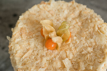 Layered cake on a plate decorated with physalis