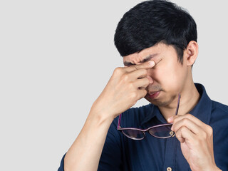 Young businessman tried from working gesture take off glasses isolated