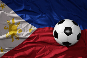 vintage football ball on the waveing national flag of philippines background. 3D illustration