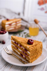 Homemade honey cake with cherry on plate