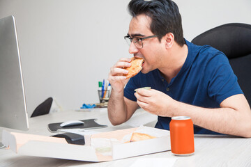 Man chilling have food while working and surfing the internet on his workstation.