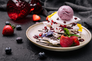 meringue slices and blueberry ice cream ball with berries