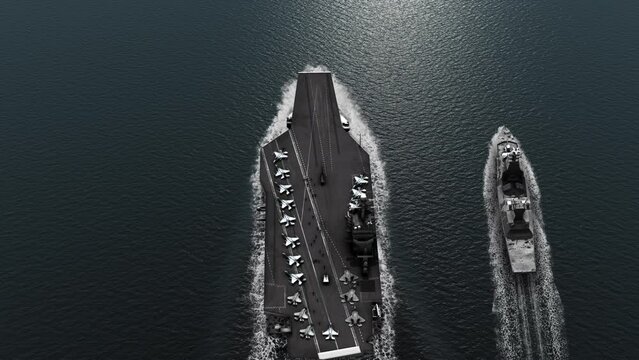 Aircraft carrier with Battleship crossing the sea 
High altitude view of Aircraft carrier and Battleship in the ocean
