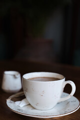 cup of coffee on a table, vintage color photograph, film noise and grain in the photograph. Vertical frame, selective focus, blurred background. Idea for screensaver or menu, articles about coffee