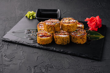 warm sushi with ginger and wasabi on a black wood