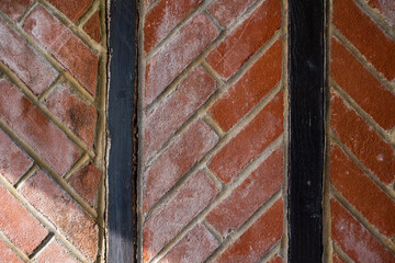 Herringbone red brick pattern between vertical timbers