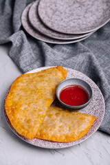 Fried burekas with filling on stone plate