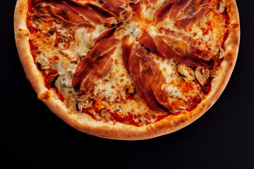 Pizza with jamon, cheese and mushrooms on black