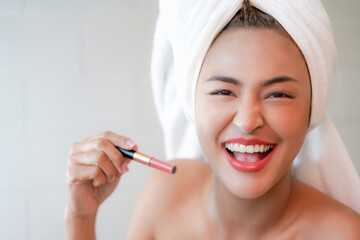 Young Women in white towel showing lipstick.