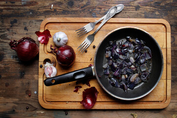 Fototapeta Fried red onion and garlic in a pan. obraz