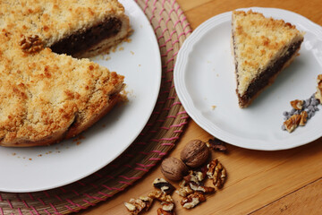 Traditional italian cake Sbrisolona cut in slices made with walnuts and chocolate on a plate on wooden table