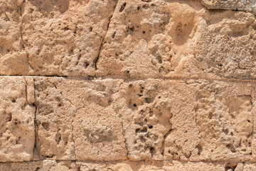 Old weathered sandstone wall closeup as stone background 