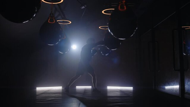 Shadow fight. Silhouette of boxer preparing for big fight doing leads and others hooks. Male boxer shadow on the smoky background. People and sport concept