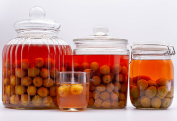 Fototapeta na wymiar Glass jar of Japanese plum wine 'Umeshu'.Plum fruit mixed with vodka and sugar. The pickling period is 1 year.