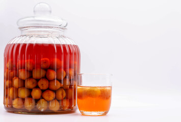Glass jar of Japanese plum wine 'Umeshu'.Plum fruit mixed with vodka and sugar. The pickling period is 1 year.