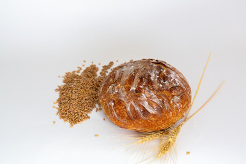 Baked bread and wheat. White background.