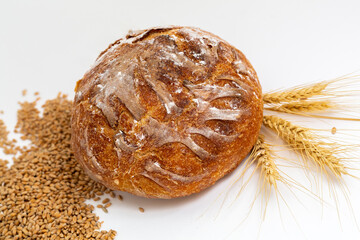 Baked bread and wheat. White background.