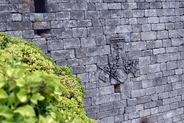 Stone shield and Maltese cross in Trevejo castle. Caceres. Spain