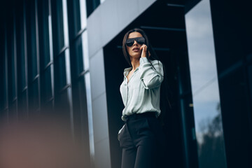 Young business woman talking on the phone by the business center