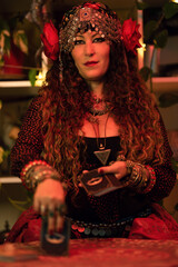 fortune-telling witch laying a tarot card from the deck on the table
