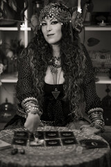 seer pointing to one of the tarot cards in the deck on her desk