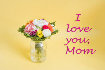 mother's day concept with pink flowers over yellow background a bouquet of wild flowers in on the table, background for mom's day, free space
