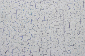 White peeling paint on the wall. Old concrete wall with cracked flaking paint. Weathered rough...