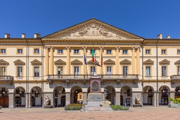 Fototapeta na wymiar Aosta, Italy. View of the external facade of the City Hall in Émile Chanoux Square. In front of the building is the Monument to the Aosta Valley soldier. April 17, 2022.