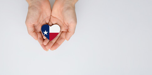 Fototapeta Texas state flag in the shape of a heart in female hands. Flat lay, copy space. obraz