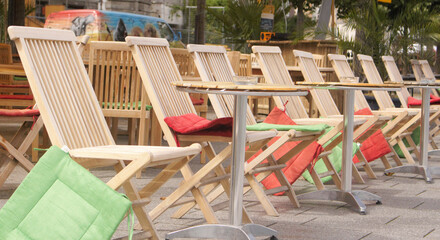 Fototapeta na wymiar eine Reihe Holzstühle am Strand von Remagen