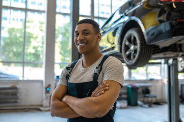Pleased African American car technician in the workplace