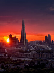 Fototapeta na wymiar Elevated view of the London skyline during a cloudy sunset with intense red colors and sunlight during autmn time, England