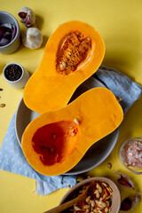 Butternut squash cutted in halves pumpkin on yellow background