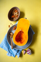 Butternut squash cutted in halves pumpkin on yellow background